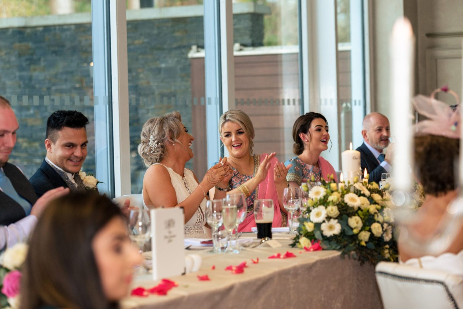 Guests collectively applauding at a wedding reception.