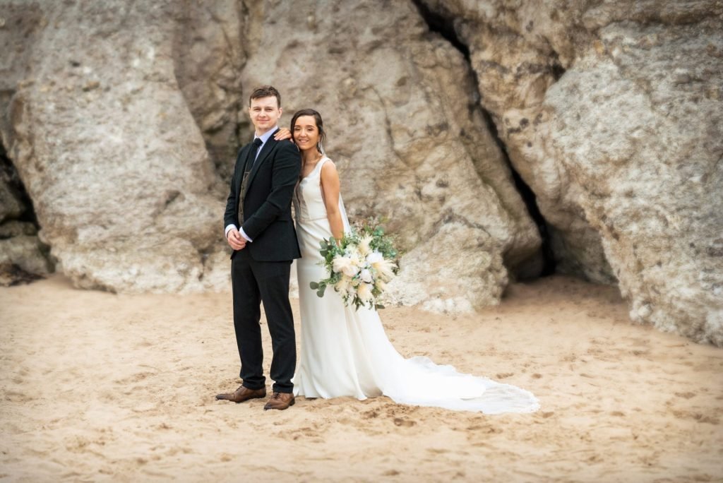 A couple sharing a moment on the beach on their wedding day