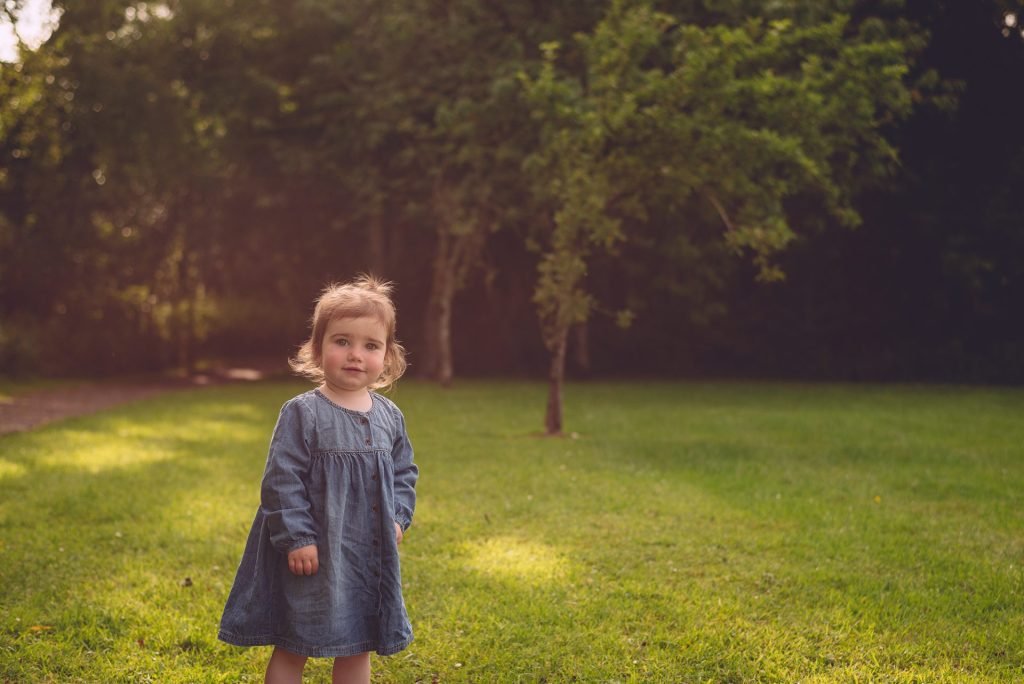A little girl in a blue dress captured by a Northern Ireland family photographer.