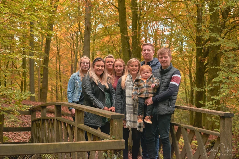 Family Photographer A family posing on a wooden bridge in the woods.